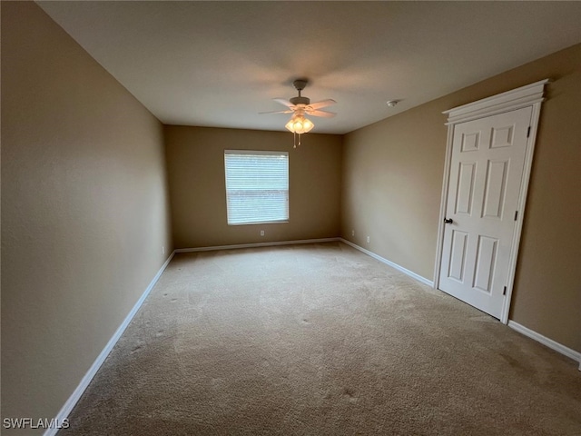 carpeted spare room featuring ceiling fan