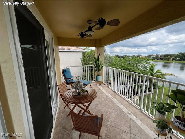 balcony with a water view and ceiling fan