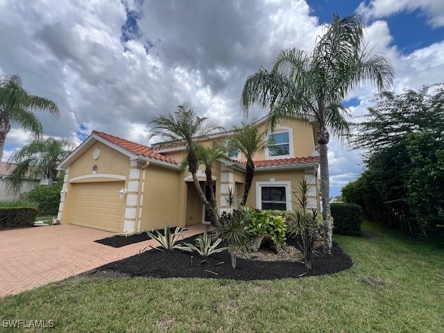 mediterranean / spanish-style house with a front yard and a garage