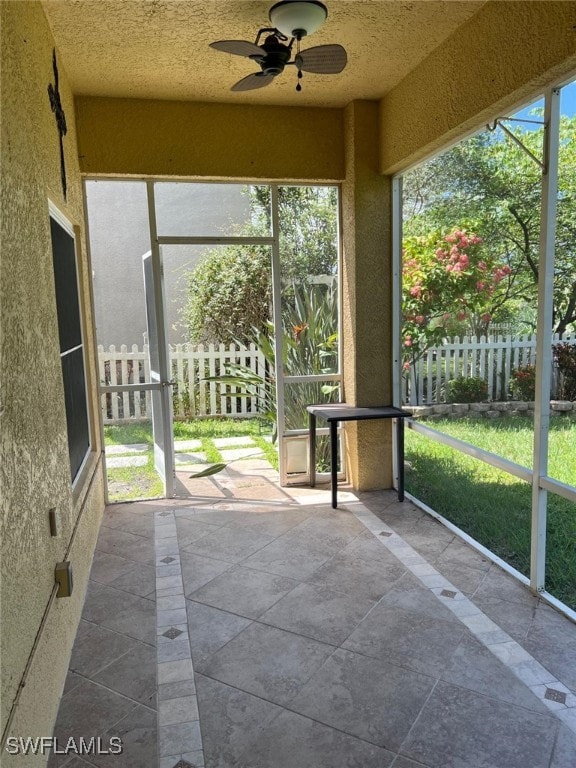 unfurnished sunroom featuring ceiling fan