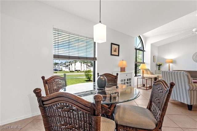 tiled dining room with lofted ceiling and ceiling fan