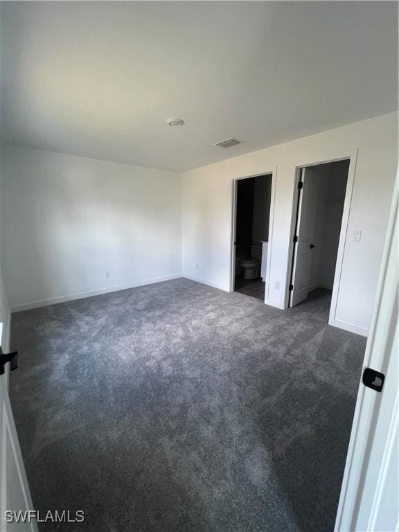 spare room with dark carpet