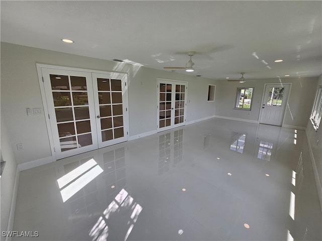 unfurnished living room with tile patterned flooring, ceiling fan, and french doors