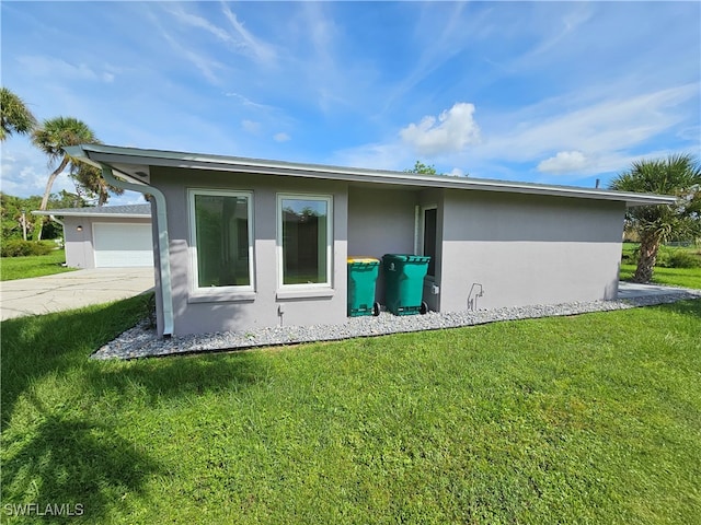 back of property featuring a lawn and a garage