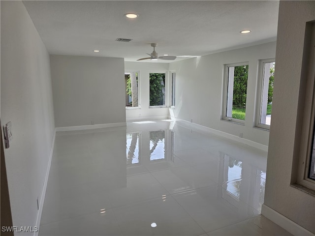 spare room with ceiling fan, light tile patterned floors, and a textured ceiling