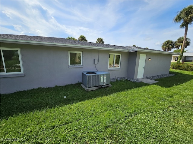 rear view of house with a yard and central air condition unit