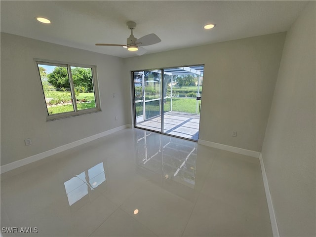 unfurnished room with ceiling fan, a wealth of natural light, and tile patterned flooring