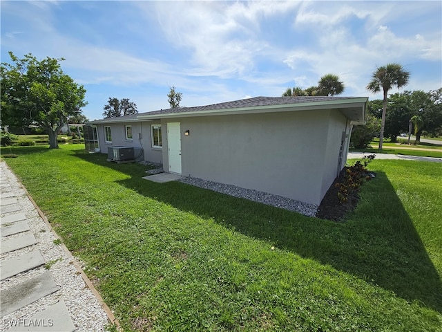 view of property exterior featuring central air condition unit and a lawn