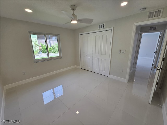 unfurnished bedroom with a closet, ceiling fan, a textured ceiling, and light tile patterned flooring