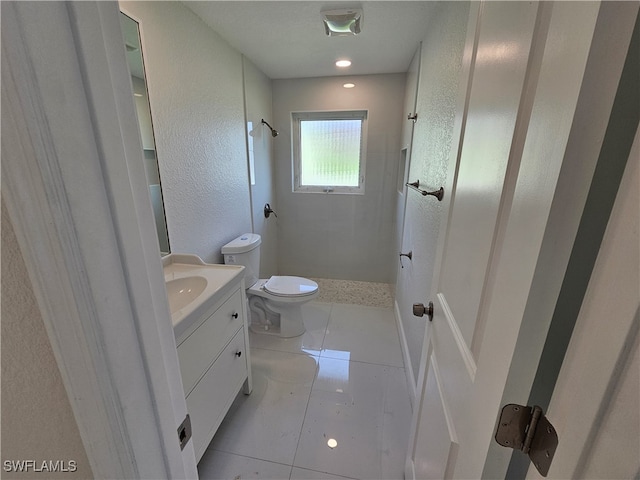 bathroom featuring vanity, toilet, tile patterned floors, and walk in shower