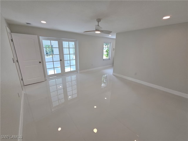 spare room with a wealth of natural light, ceiling fan, and tile patterned flooring