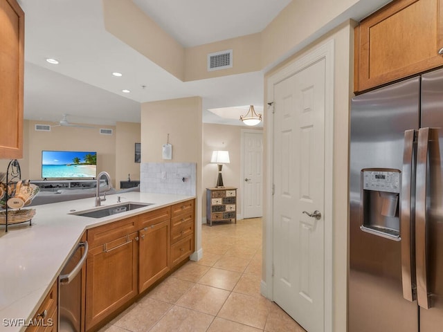 kitchen with light tile patterned floors, stainless steel appliances, sink, ceiling fan, and hanging light fixtures