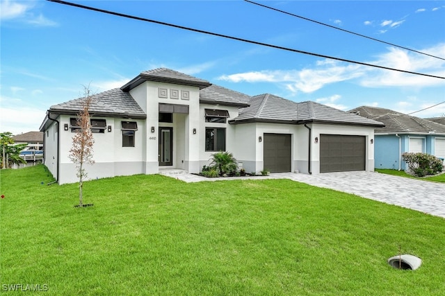 prairie-style home featuring a garage and a front lawn