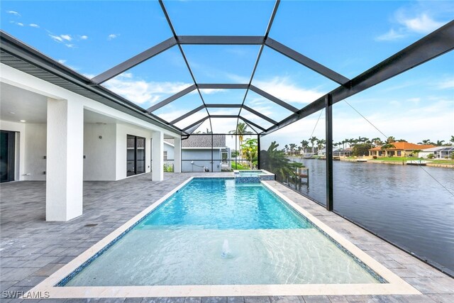 view of swimming pool featuring glass enclosure, a patio area, and a water view