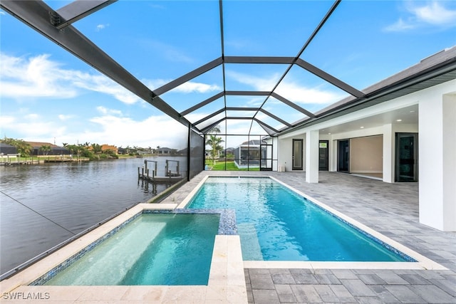 view of swimming pool featuring glass enclosure, a patio, and a water view