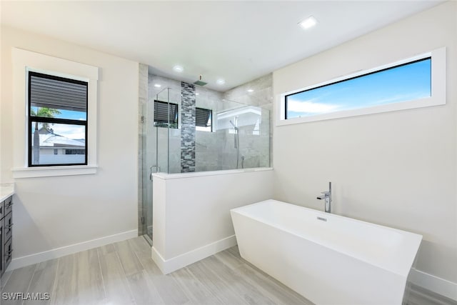 bathroom with plenty of natural light, vanity, separate shower and tub, and hardwood / wood-style floors