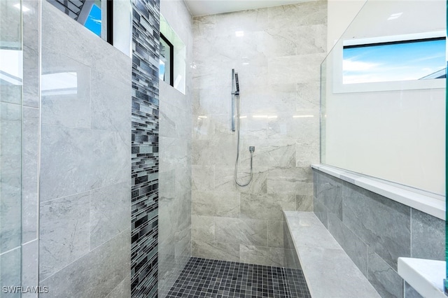 bathroom with a wealth of natural light and a tile shower