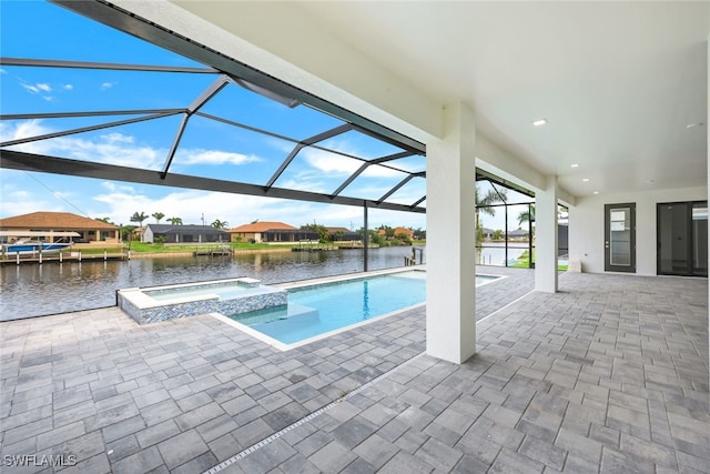 view of swimming pool featuring a water view, glass enclosure, a patio area, and an in ground hot tub