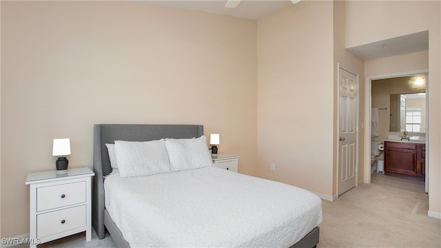 carpeted bedroom featuring ceiling fan and ensuite bathroom