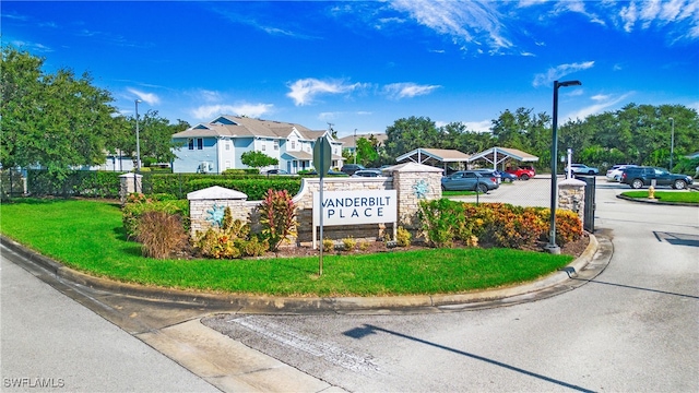 community sign featuring a lawn