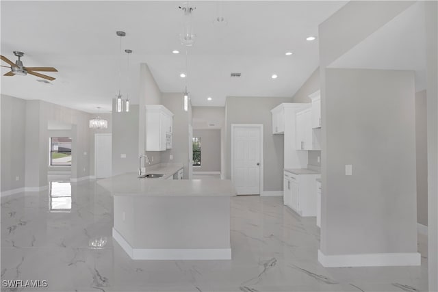 kitchen with ceiling fan with notable chandelier, sink, decorative light fixtures, and white cabinets