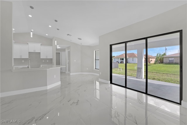 unfurnished living room featuring lofted ceiling and sink