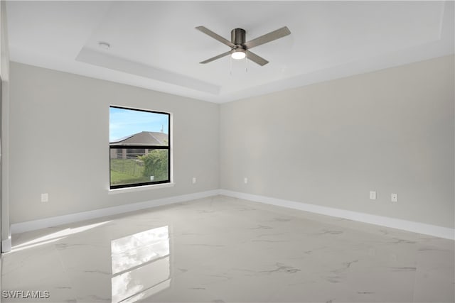 empty room with a tray ceiling and ceiling fan