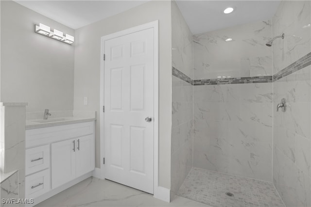 bathroom with vanity and a tile shower