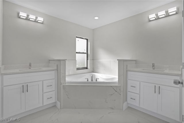 bathroom featuring tiled tub and vanity