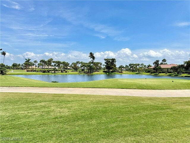 view of property's community with a lawn and a water view