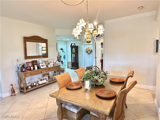 dining room with an inviting chandelier, ornamental molding, and light tile patterned flooring