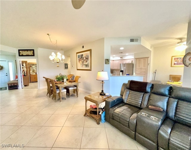 tiled living room with ceiling fan with notable chandelier