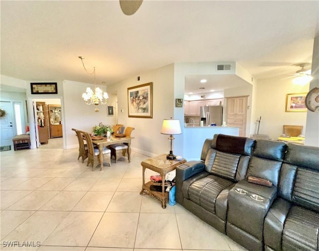 living room with light tile patterned floors, baseboards, visible vents, and ceiling fan with notable chandelier