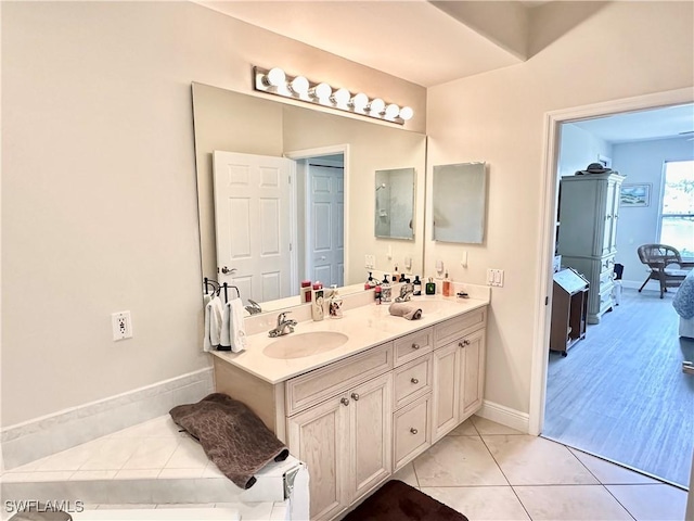 full bathroom featuring double vanity, tile patterned flooring, a sink, and baseboards