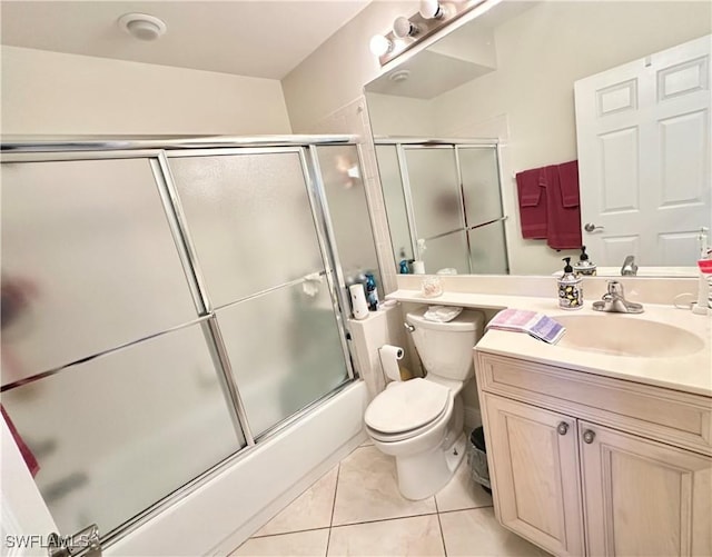 full bath featuring tile patterned flooring, enclosed tub / shower combo, vanity, and toilet