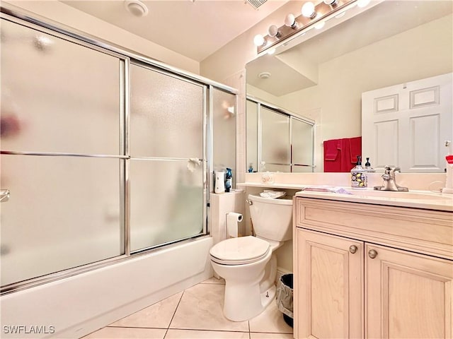 bathroom with visible vents, toilet, tile patterned flooring, combined bath / shower with glass door, and vanity