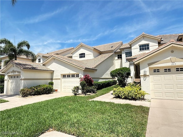 view of front of house with a garage, a tile roof, driveway, stucco siding, and a front yard