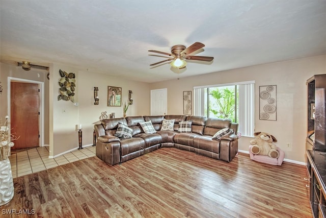 living room with ceiling fan and light wood-type flooring