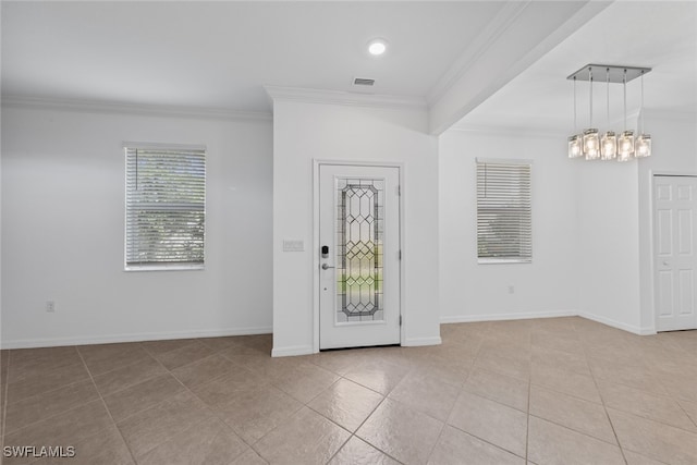 tiled entryway with a chandelier and crown molding