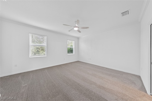 empty room featuring ornamental molding, light colored carpet, and ceiling fan