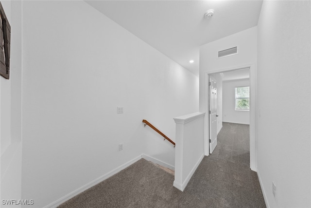 hallway featuring dark colored carpet