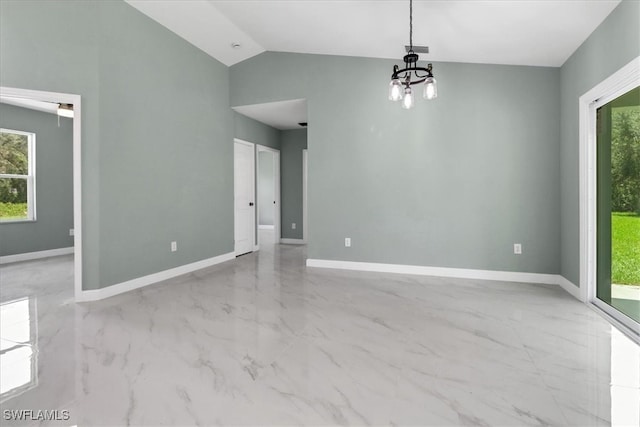 unfurnished room featuring lofted ceiling and an inviting chandelier