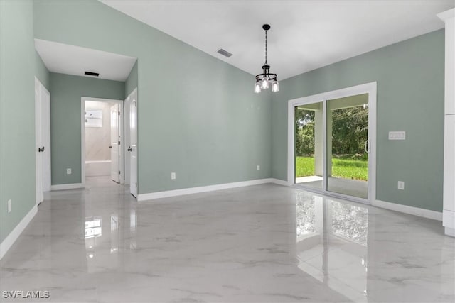 spare room featuring an inviting chandelier