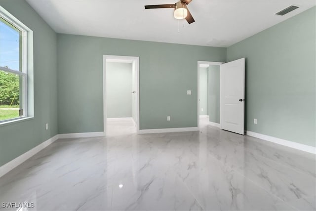 unfurnished room with ceiling fan and plenty of natural light