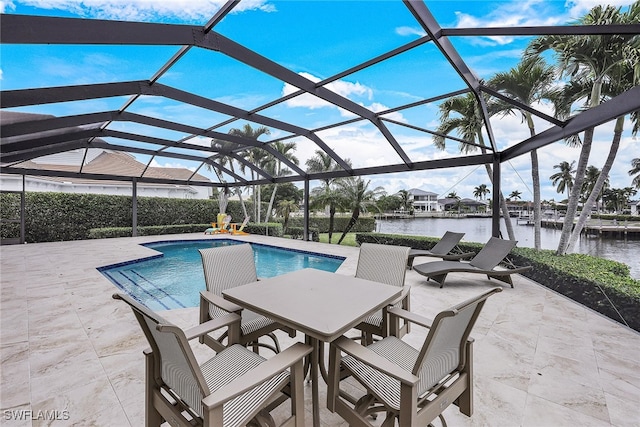 view of pool with a lanai, a water view, and a patio area