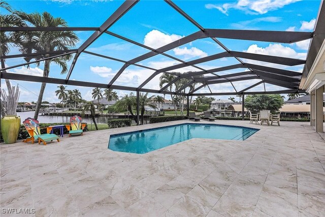 view of swimming pool featuring glass enclosure, a water view, and a patio area