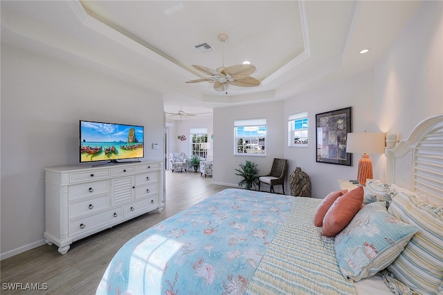 bedroom featuring ceiling fan, hardwood / wood-style flooring, and a raised ceiling