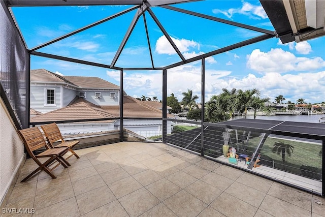 view of patio / terrace featuring a water view and glass enclosure