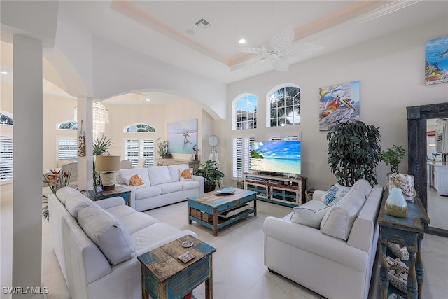 living room featuring ceiling fan and a raised ceiling