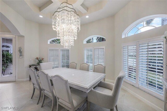 dining room featuring a healthy amount of sunlight, light tile patterned flooring, and an inviting chandelier